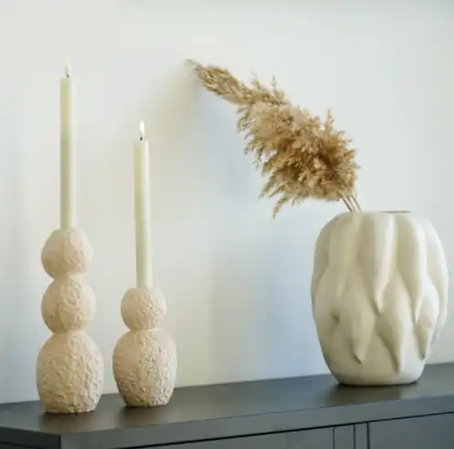 un duo de bougeoirs en ciment aux formes organiques